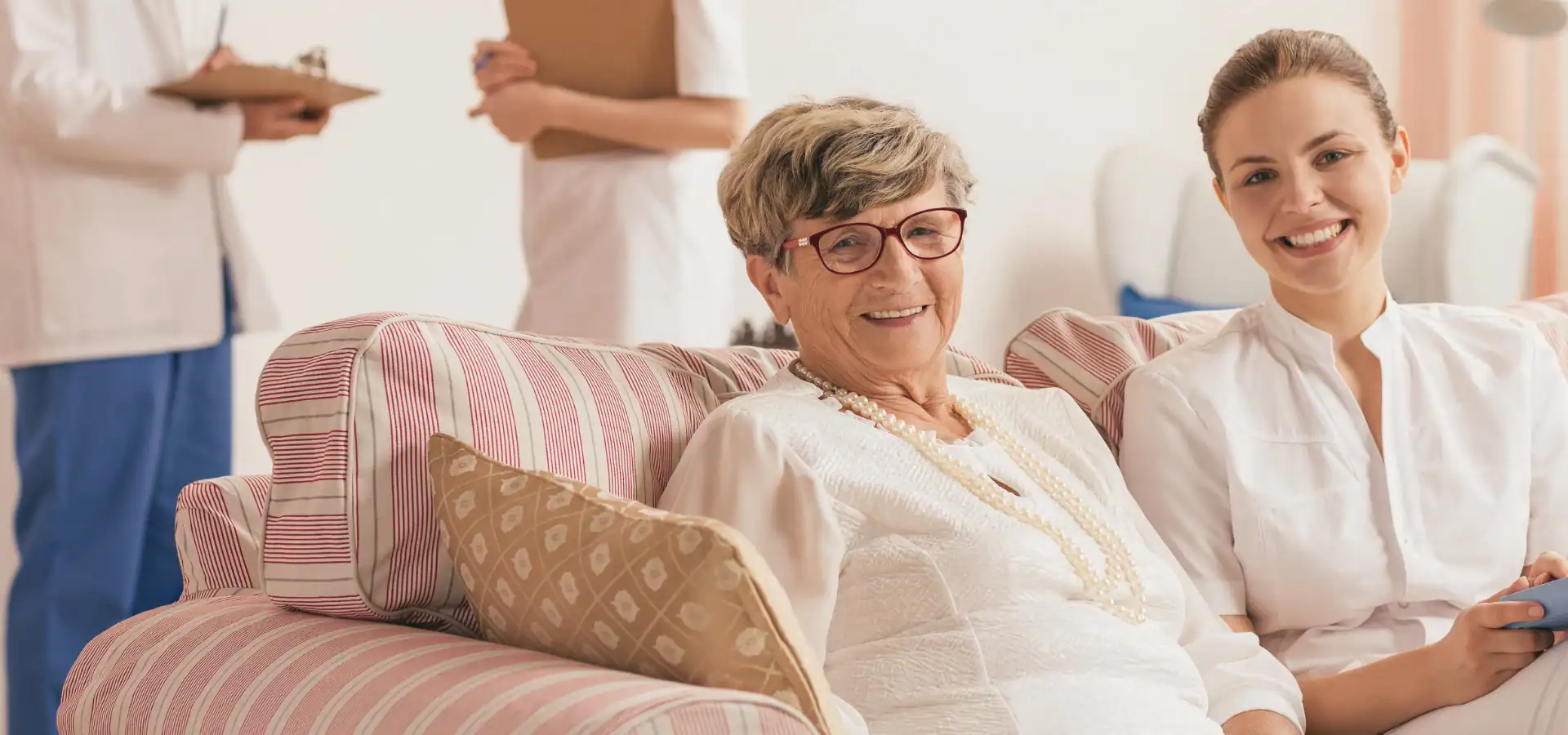 Two women laughing together on a couch