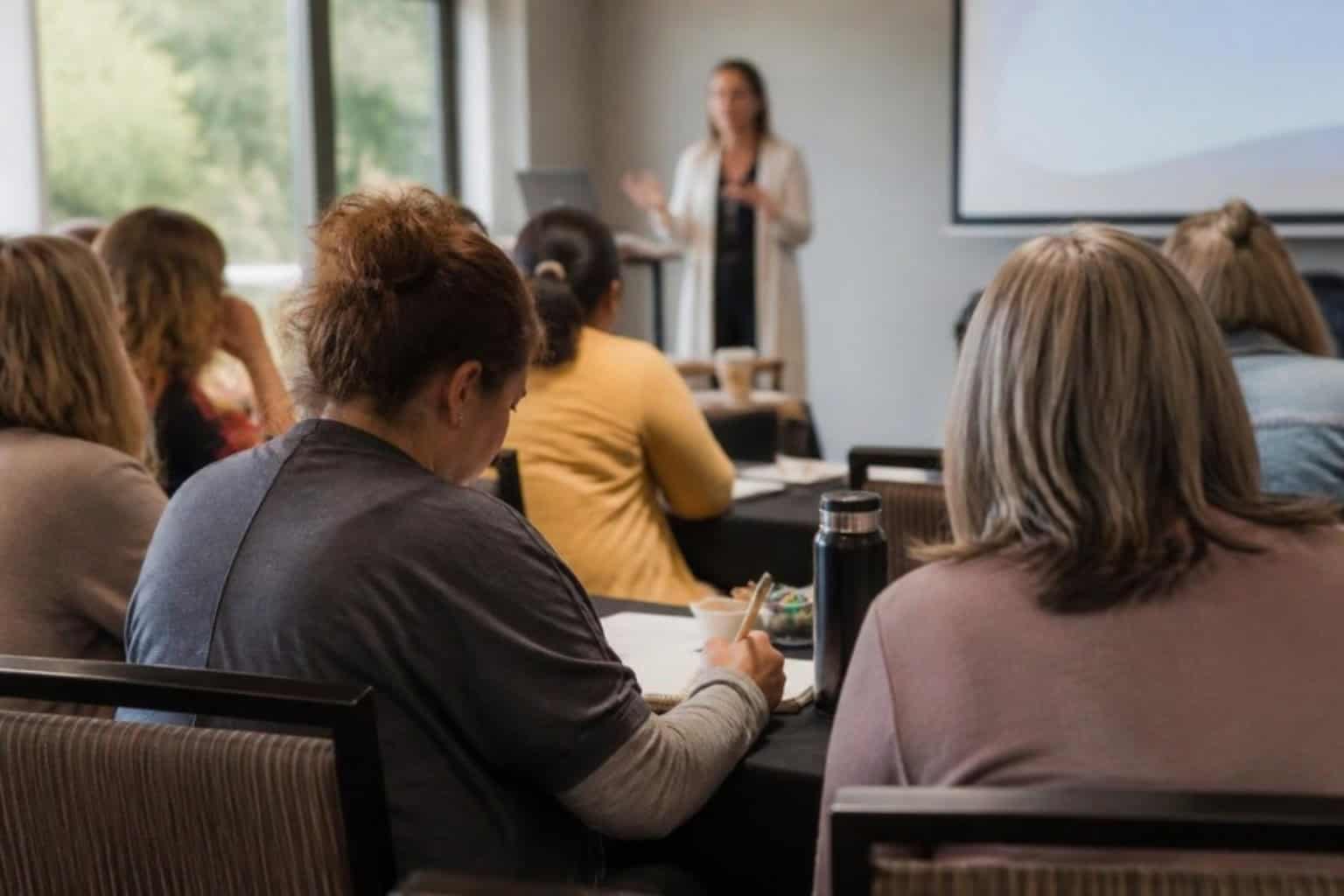Care professionals take notes during a dementia care training seminar
